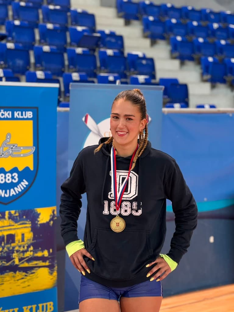 Mlada veslačica sa osvojenom medaljom.